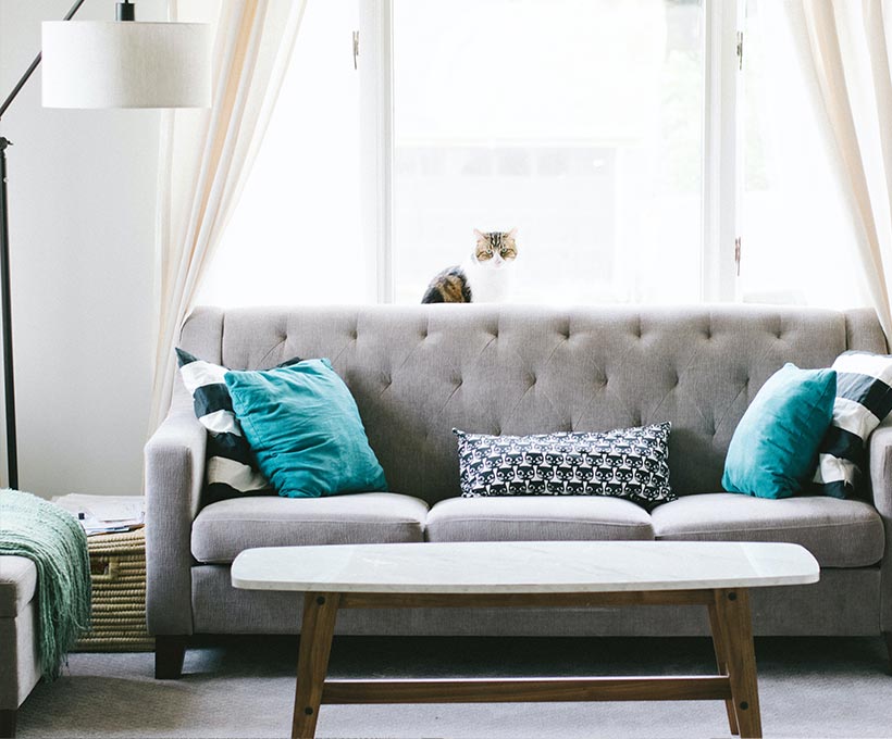 白色抬燈旁有一灰色長沙發後有落地窗